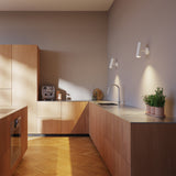 White Expo Wall light with aluminum base and slim cylindrical design mounted on a wall.