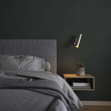 Polished aluminum Expo Wall light with cylindrical shape and slim base mounted on wall.