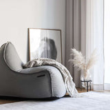 Medley Lounge Chair in Medley Grey fabric with soft, rounded shape and backrest on a white background