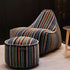 Multi-colored lounge chair and pouf with linear Paul Smith design in cotton textile on a white background