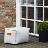 Cobana Square Pouf in black canvas fabric with hand-sewn stitches and a square shape.