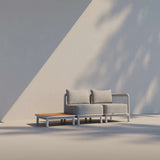 Taupe Kirra Side Table with teak wood top and powder-coated aluminum frame, outdoor setting.