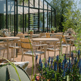 Round taupe Kirra Café Table made of powder-coated aluminum and teak wood on a light background