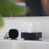 Black stainless steel SACKit Bio Lamp with heat-resistant glass and ethanol container on a wooden surface outdoors