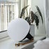 Round SACKit Light 250 outdoor lamp with hempen rope handle and white light dome on a wooden surface