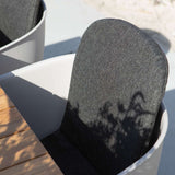 Outdoor slipover cushion for Patio Chair no. One in black with non-slip backing on a wooden chair.