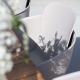 Taupe outdoor dining chair with black powder-coated steel frame and recycled plastic shell.