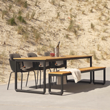 Taupe shell outdoor dining chair with black powder-coated steel frame and drain holes.