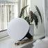 Two SACKit Light 250 outdoor lamps with a white dome and hempen rope handles placed on a wooden surface outdoors.