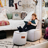 Cobana Junior Lounge Chair and pouf in a neutral indoor setting with soft fabric and rounded shapes.