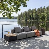 sackit modular outdoor lounge sofa in grey with cushions and side table on a lakeside terrace surrounded by trees and designed for Nordic weather