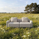 sackit Cobana two seat outdoor sofa with light cushions set in a sunny wildflower meadow and designed for Scandinavian living
