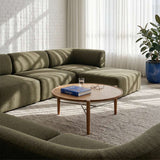 Olive green Fjord Sofa seat section in a calm Scandinavian living room with a round wooden coffee table and bright natural light from sheer curtains by sackit