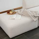 sackit fjord sofa with open end styled in a calm Scandinavian interior with a soft blanket open book and tray of fruit for a cozy setting