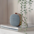Portable Go Wood speaker with smoked oak frame and Fiord textile by KVADRAT on a white surface