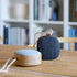Portable Go Wood speaker with smoked oak wooden frame and Fiord textile from KVADRAT on a white background