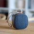 Portable Go Wood speaker with smoked oak frame and Fiord textile from KVADRAT on a white background