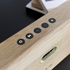 Bluetooth speaker with natural oak wood and Fiord textile from KVADRAT in a home setting
