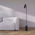 Black Expo Floor lamp with matte aluminum body and polished marble base in a living room setting