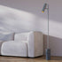 Grey floor lamp with aluminum body and polished marble base, featuring a slim, modern design.
