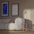 Grey aluminum table lamp with marble base and warm lighting on a white background.