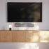 Sleek soundbar with textile front and ABS plastic body in neutral color, designed for music and TV use.