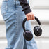 Black over-ear headphones held by a person in casual clothing showing the padded headband and cushioned ear cups from sackit