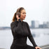 Woman wearing sackit Touch 310 over ear headphones by the waterfront during an outdoor workout