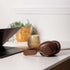 sackit Touch 310 brown over ear headphones resting beside an open laptop on a white desk in a warm home office setting