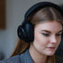 Woman wearing black Touch 400 over-ear headphones from sackit with hybrid active noise cancellation for immersive audio experiences