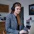 Woman wearing sackit Touch 400 over ear headphones with hybrid ANC while working on a laptop at home
