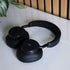 Black sackit Touch 400 over ear headphones resting on a white surface with padded ear cups and headband in a softly styled indoor setting