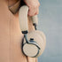 sackit Touch 400 beige over ear headphones held by a person showing padded ear cups and an adjustable headband