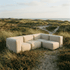 Cream five seater corner outdoor sofa nestled among coastal dunes with soft cushions and weather resistant design by sackit europe