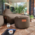Round Cobana Pouf in grey Cobana fabric with hand-sewn stitches, suitable for indoor and outdoor use.