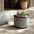 Round Cobana Grey pouf with textured fabric and hand-sewn stitches for indoor and outdoor use
