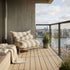 Striped bolster outdoor cushion on a lounge sofa on a sunny balcony overlooking the city and water by sackit