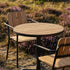 Round outdoor café table with teak wood top and black powder-coated aluminum legs on a terrace setting