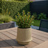 Sand-colored ceramic Gaia 16 outdoor planter with fluted surface and drainage hole