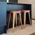 Nordic bar stool in Terra Black leather with oak wood and cross-stitch detailing, 73 cm height.