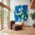 Brown upholstered lounge chair in a Scandinavian living room with abstract blue and green artwork natural wood windows woven rug and sackit design