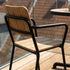 Kirra Patio Chair in black powder-coated aluminum and teak wood, outdoor setting.