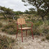 Chestnut Kirra Patio Chair with teak wood and aluminum frame on outdoor setting