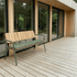 Green seat cushion fitted to a wooden outdoor bench on a timber deck beside a modern glass home from sackit