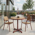 Round outdoor café table with teak wood top and powder-coated aluminum frame in natural setting
