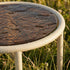 Taupe Mollis Side Table Ø50 with powder-coated aluminum frame and smoked tempered glass top outdoors.