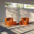 Two soft orange indoor lounge seats with backrests arranged in a bright modern room with sunlight and leafy shadows across the walls and floor