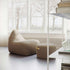 sackit indoor lounge chair and matching pouf in warm taupe upholstery beside a bright window in a refined Scandinavian living space