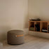 Round Teddy Brown SACKit Pouf Indoor with soft fabric and side handle on a light floor background