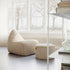 sackit cream ribbed lounge chair with matching pouf in a bright indoor setting by large windows